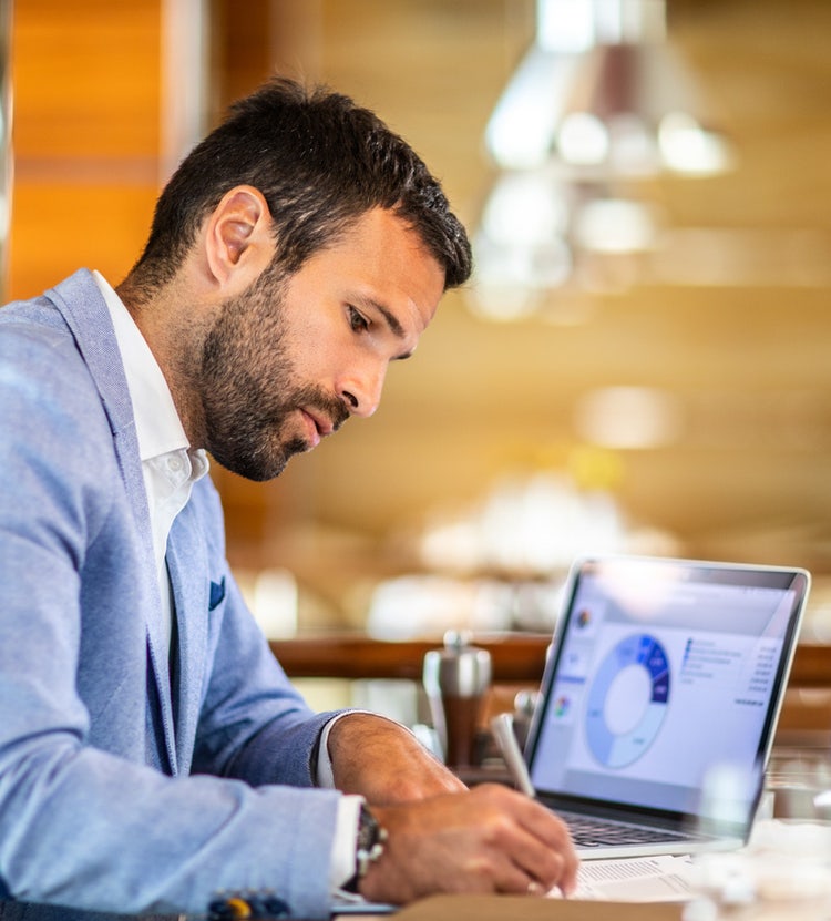 Entrepreneur writing on a document - Avendra International's business services.